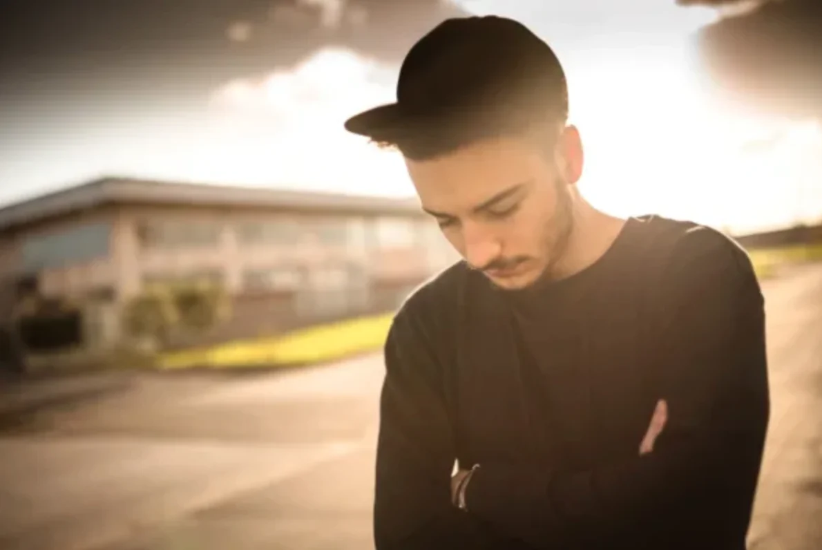 man walking outside looking down